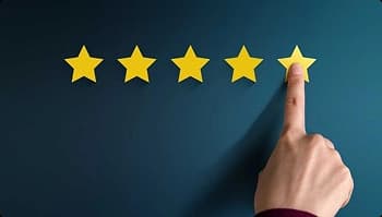 person`s hand pointing at five yellow stars on blue background