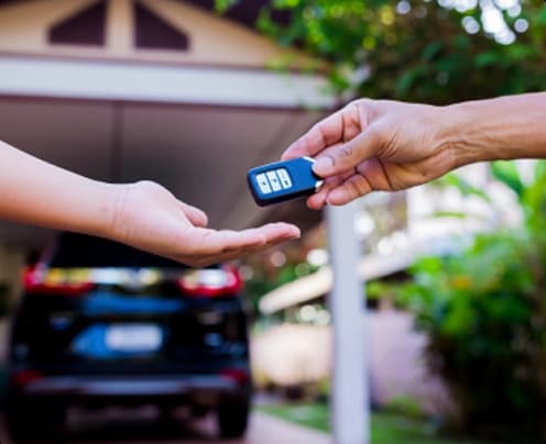 customer receiving car keys at door to door vehicle delivery
