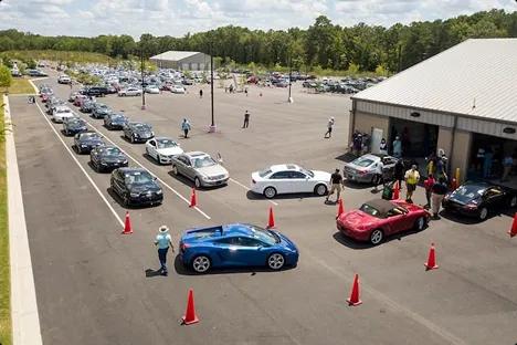 Auto auction inspection lane Long line of cars waiting at an auto auction inspection lane with orange cones and staff