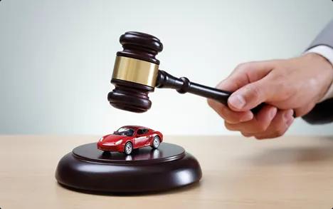 Auto Auction Car Transport Judge gavel striking near a small red car model symbolizing auto auction purchases and releases