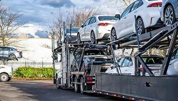 Open carrier loaded for dealer transport open car carrier loaded with sedans near trees ready for dealer transport