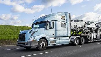 Semi truck with car hauler on highway silver semi truck with car hauler driving on highway with loaded vehicles