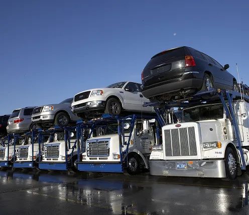 Fleet of open carriers at staging lot row of open car carriers loaded with vehicles at auction