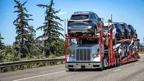 Open carrier hauling SUVs on highway open car carrier hauling multiple SUVs on a highway for auto transport