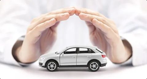 Auto transport insurance protection hands covering a car model representing auto transport insurance coverage