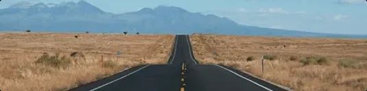Distance long open highway toward mountains showing route distance factor