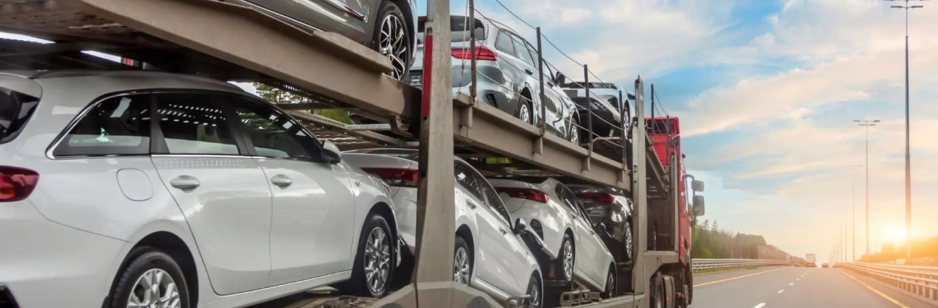 Wimple Auto Transport help center - expert car shipping support Professional car carrier truck transporting multiple vehicles on highway at sunset