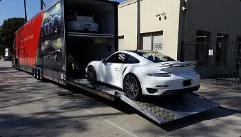 Enclosed loading for secure luxury transport white sports car loading into enclosed trailer via ramp for secure luxury transport