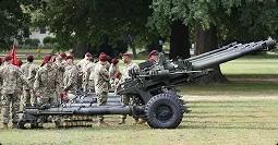 Field artillery formation on base service members standing with field artillery during training on base