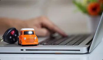 Buy nationwide ship home car keys and toy car on laptop showing buy online and ship home