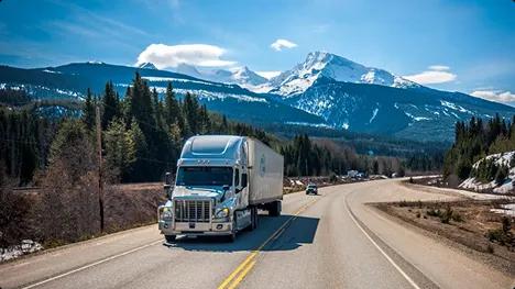Long distance auto transport scenic mountain route semi truck driving on a scenic mountain highway in clear weather symbolizing long distance auto transport
