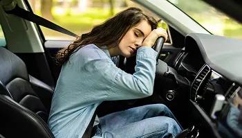 Focus on school not miles student resting in driver seat choosing car shipping instead of long drive