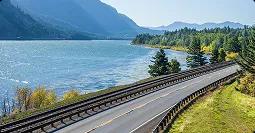 Scenic routes for West Coast deliveries scenic highway running along a lake with mountains and evergreen trees