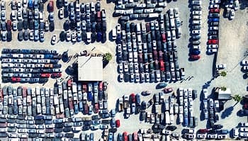 Auto auction vehicle lot Top down aerial of a crowded auto auction lot with rows of parked vehicles