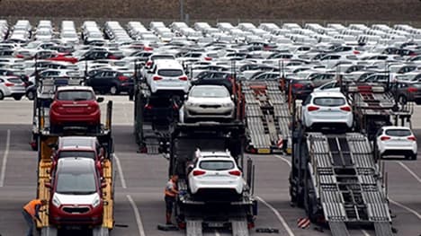 Dealership lot loading for reseller auto transport multiple car carriers loading vehicles at a large dealership lot showing reseller auto transport