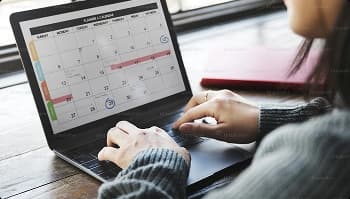 Schedule your car shipping pickup dates person checking a calendar on a laptop to schedule car shipping pickup dates