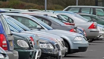 Vehicles staged in parking lot for pickup row of parked vehicles in a lot ready for dealership pickup