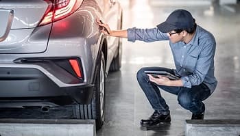 Delivery inspection with photo documentation technician inspecting a vehicle and recording condition during delivery