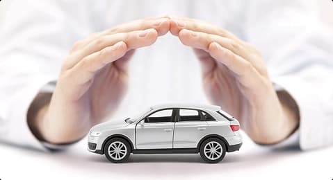 Auto transport insurance protection hands covering a car model representing auto transport insurance coverage