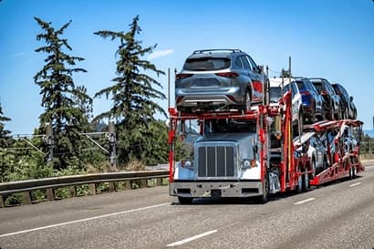 Car hauler transporting vehicles on the highway car hauler truck transporting multiple vehicles on the highway during a clear day