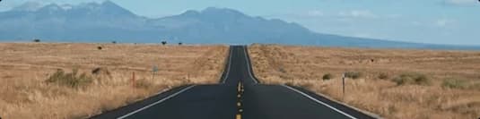 Distance long open highway toward mountains showing route distance factor