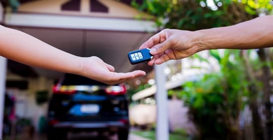 Door to door car key handover person receiving door to door car delivery key in driveaway