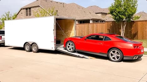Enclosed trailer car loading red sports car loading into enclosed trailer at residential driveway