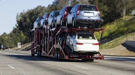 Expedited open car carrier on highway open car carrier loaded with vehicles driving on highway for expedited delivery