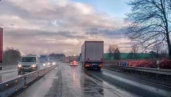 Weather delay on highway rainy highway with trucks and road work barriers causing weather delays