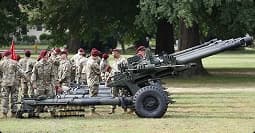 Field artillery formation on base service members standing with field artillery during training on base