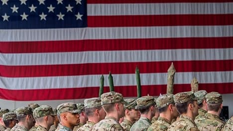 Military car shipping support for service members service members standing in formation in front of a large american flag symbolizing military car shipping support