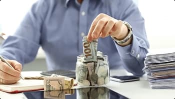 Spend less ship smart stacking dollar bills beside paperwork symbolizing savings on delivery