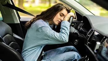 Focus on school not miles student resting in driver seat choosing car shipping instead of long drive
