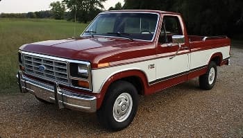 Classic pickup transport service red and white classic pickup truck parked on gravel near grass field for vintage transport