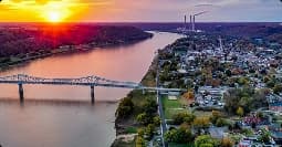 Regional car shipping across river towns aerial view of river town with bridge at sunset representing regional car shipping